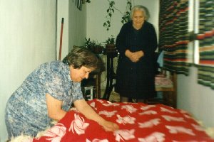 Juli cosiendo un colchn de lana bajo la atenta mirada de su madre
